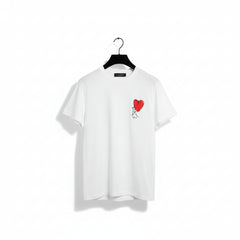 A white short-sleeve crewneck T-shirt hanging on a black hanger, featuring a small graphic on the left chest of a red heart with a black-and-white sketch figure inside it.