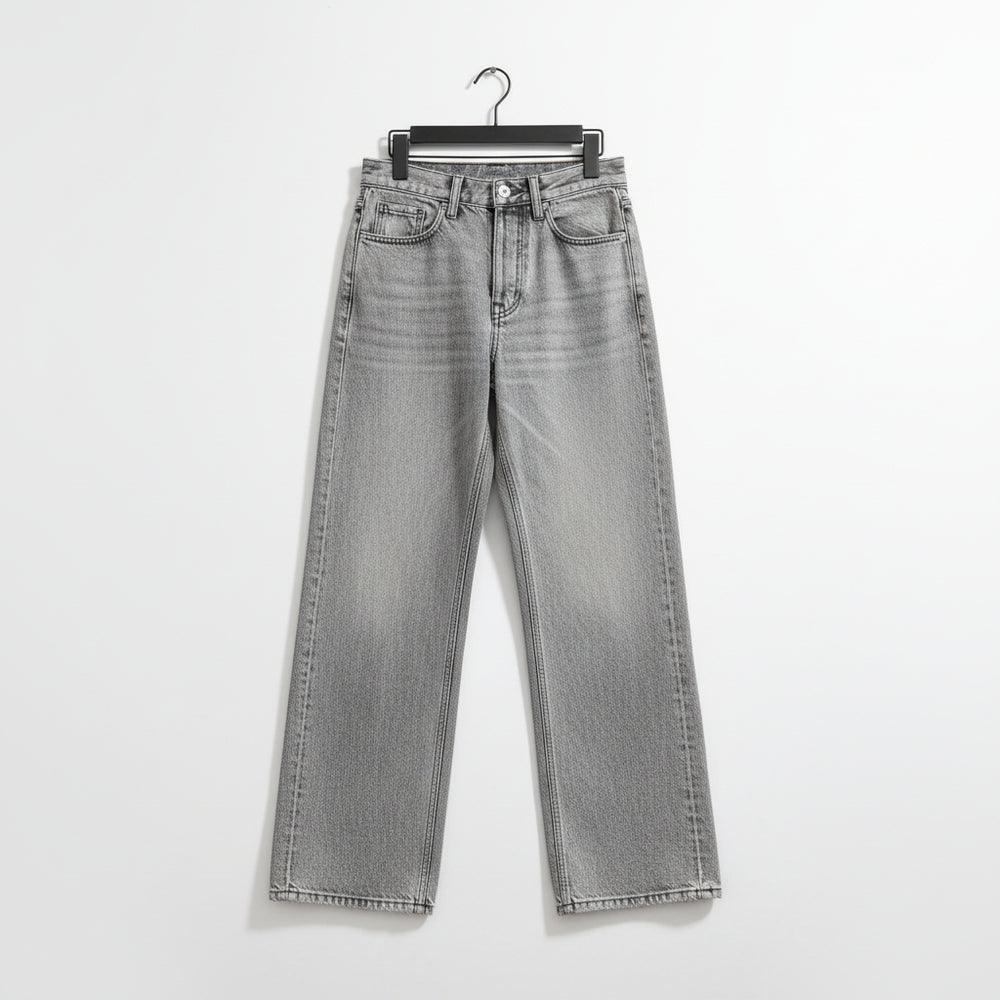 Light gray washed denim jeans with a straight-leg or wide-leg cut, laid flat on a dark marble-patterned surface. The jeans are shown hanging from a black hanger, with the cuffs rolled up to reveal the inner seam detail.