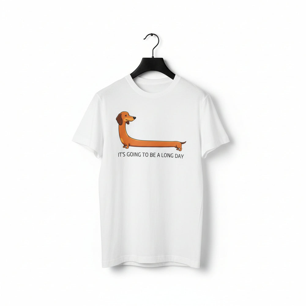 A white short-sleeve crewneck t-shirt hanging on a black hanger, featuring a cartoon dachshund graphic and the text 'IT'S GOING TO BE A LONG DAY' printed on the front.